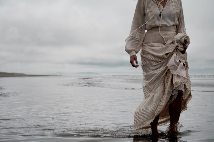 Woman in a dress walking on a beach