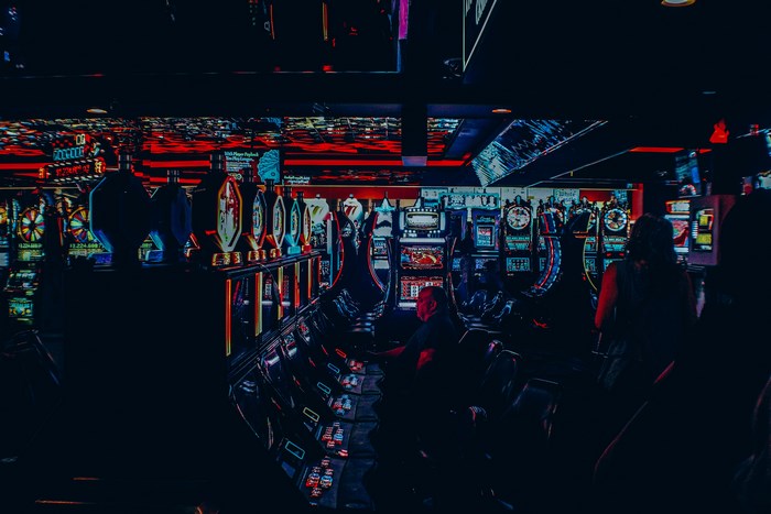 Casino with glowing slot machines and people