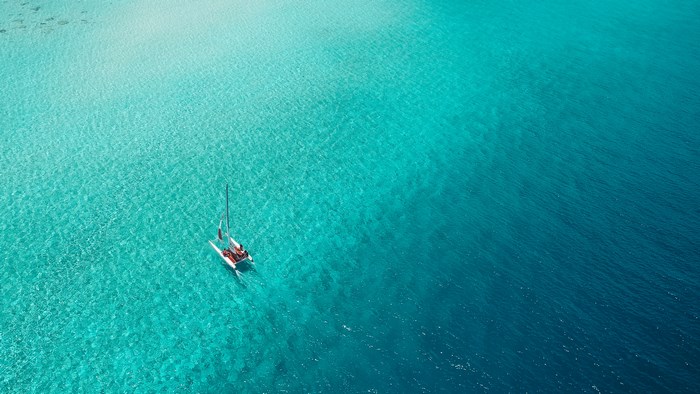 Catamaran sailing in clear turquoise water