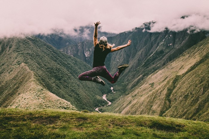 Woman jumping in a mountain valley