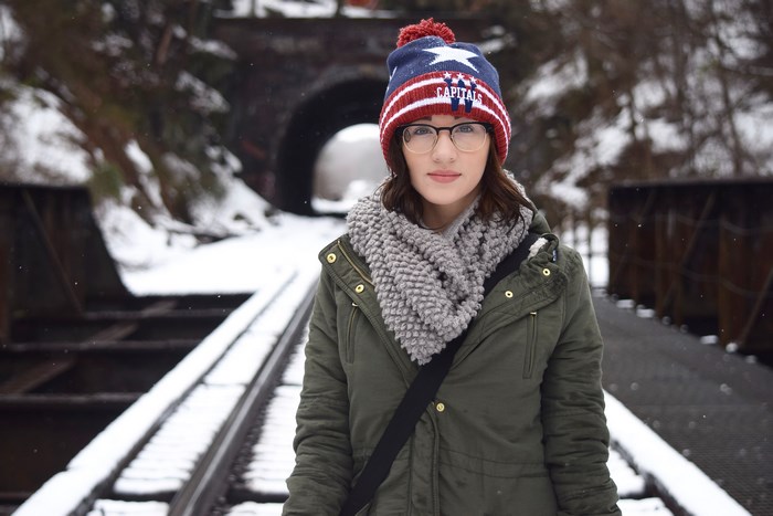 Woman wearing a Capitals beanie on a snowy train track