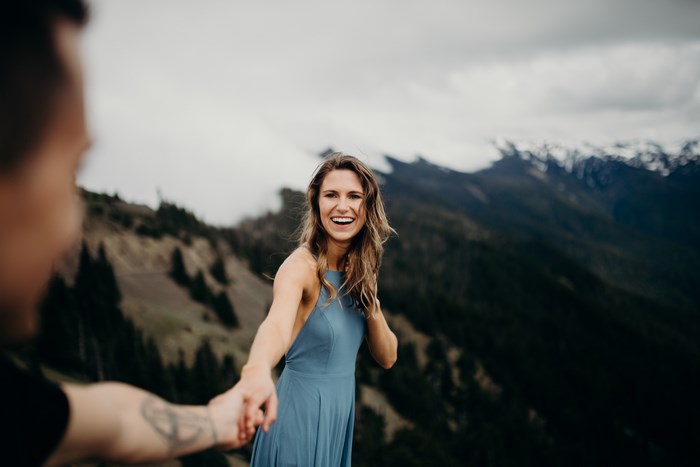 Couple holding hands on a mountain peak