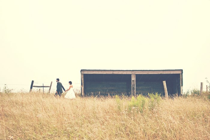 Couple walking hand-in-hand in a rural field