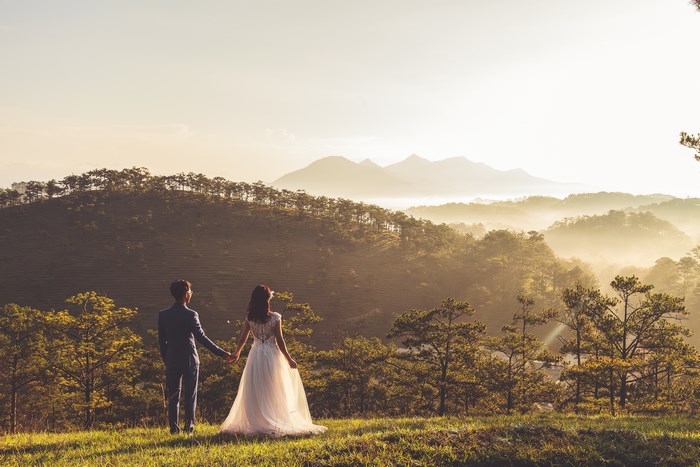 Couple holding hands on a hill at golden hour