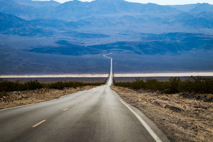 Road through desert landscape to mountains 4K
