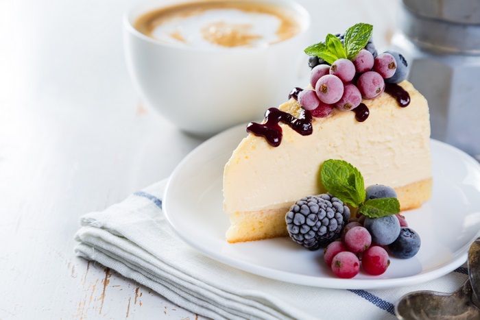 Slice of cheesecake with berries and coffee