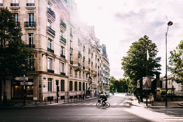 Cyclist on a Parisian street with old buildings