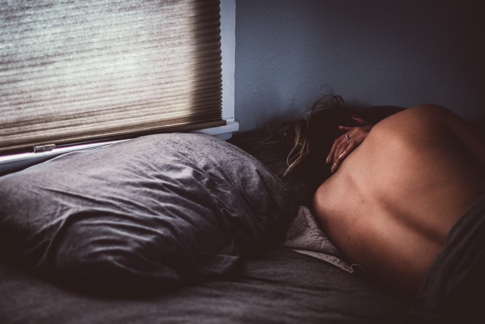 Woman sleeping in bed near window