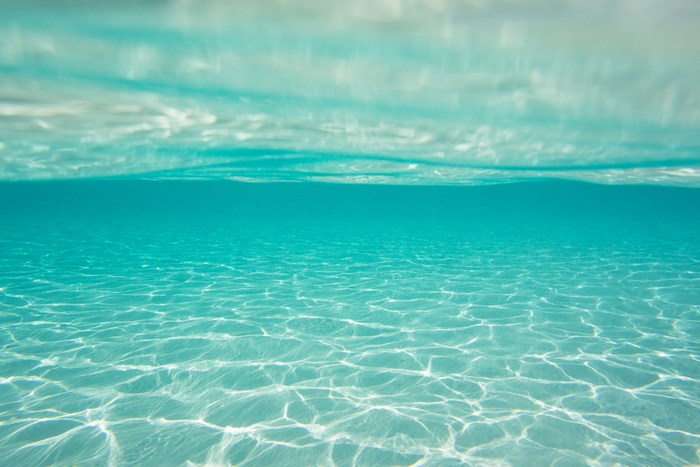 Underwater view of clear blue ocean water with light reflections