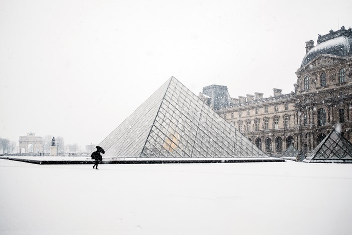 Louvre Museum Pyramid in Paris during a Snowfall