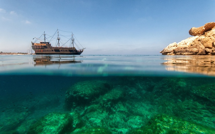 Split view of a pirate ship and underwater reef