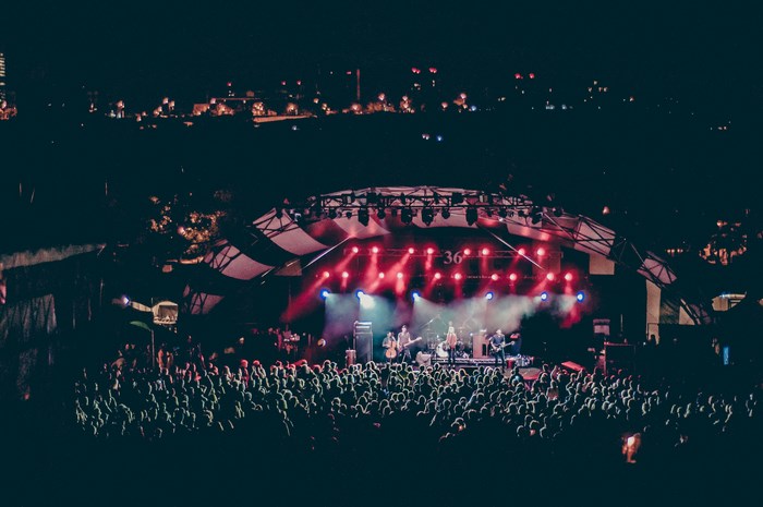 Concert stage with band and crowd at night