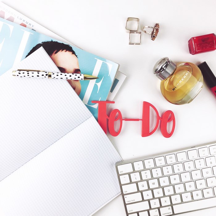 Flat lay of a desk with Burberry perfume and a keyboard
