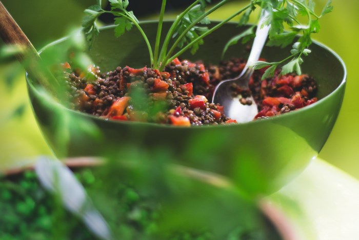 Lentil salad with tomatoes and parsley in a green bowl