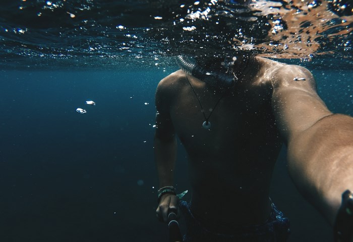 Man snorkeling underwater with GoPro
