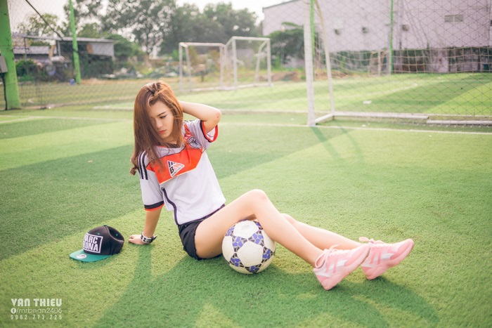 Asian girl in soccer uniform with soccer ball