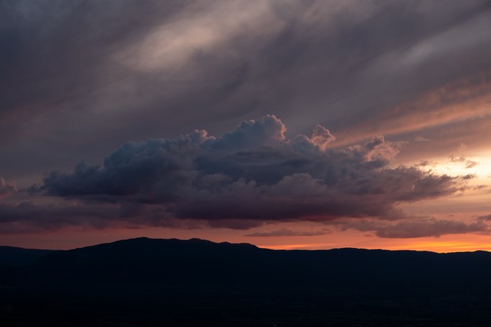 Silhouette of mountains against a dramatic sunset sky