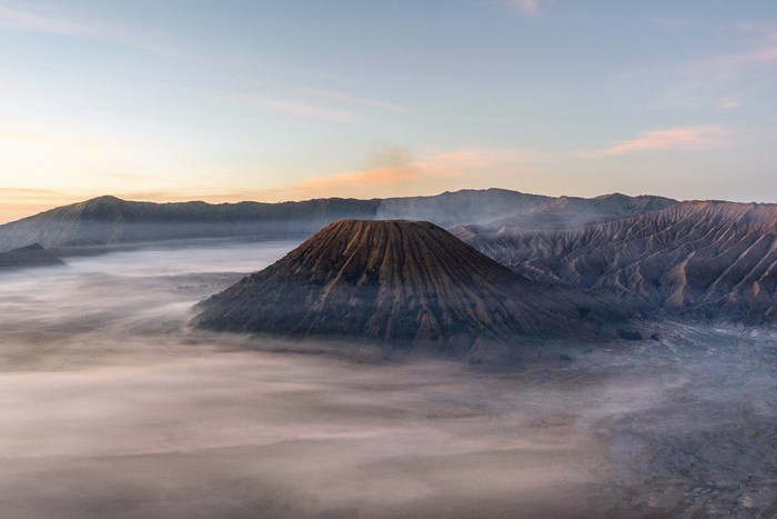 Volcano shrouded in mist at sunrise