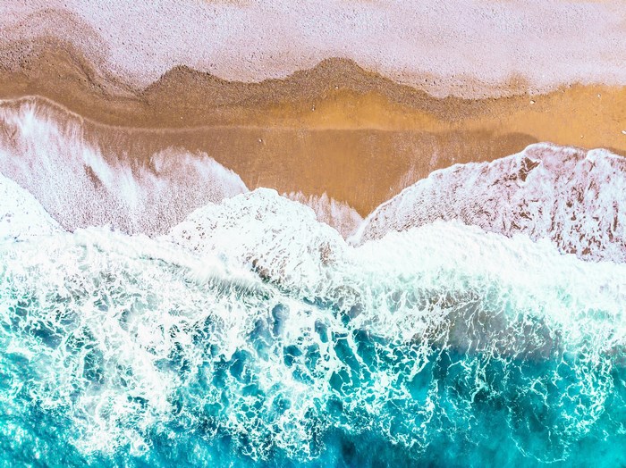 Aerial View of Ocean Waves Crashing on Beach