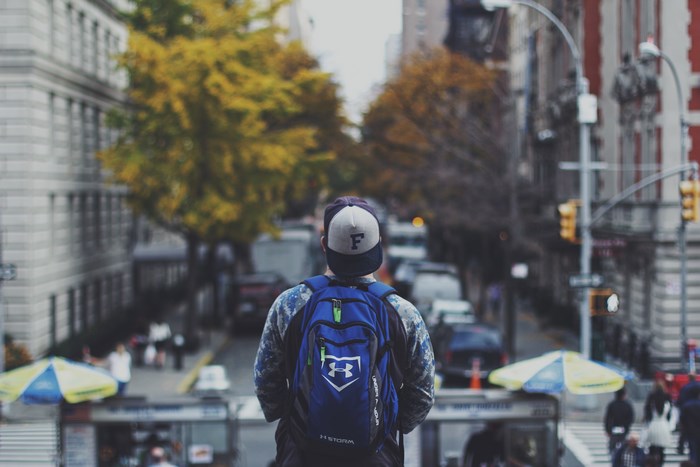 Man with backpack and cap in NYC street