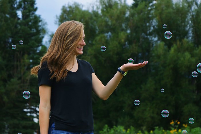 Woman playing with bubbles outdoors