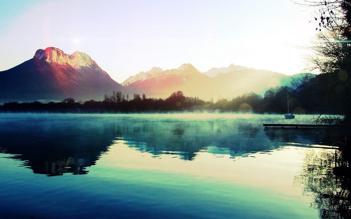 Misty lake with mountains and a pier
