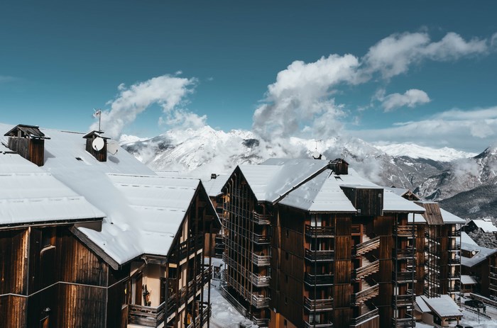 Snow-covered wooden buildings in a mountain range
