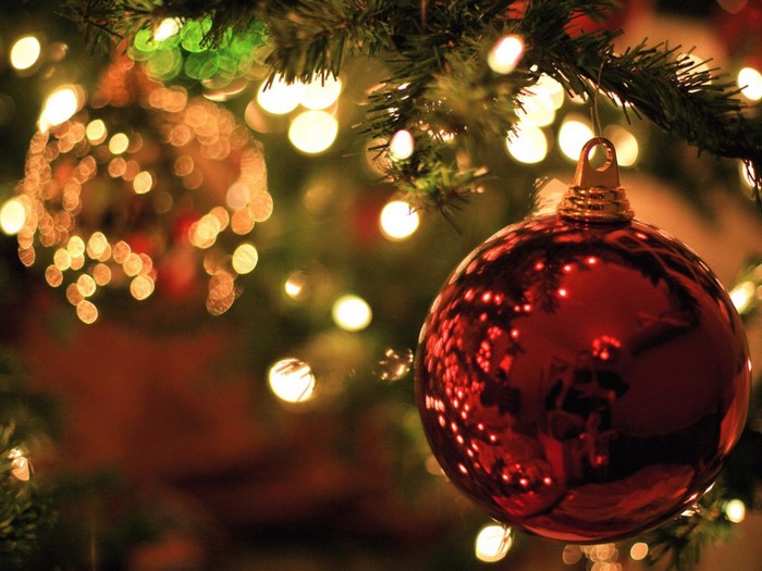 Red Christmas ornament on a tree with lights