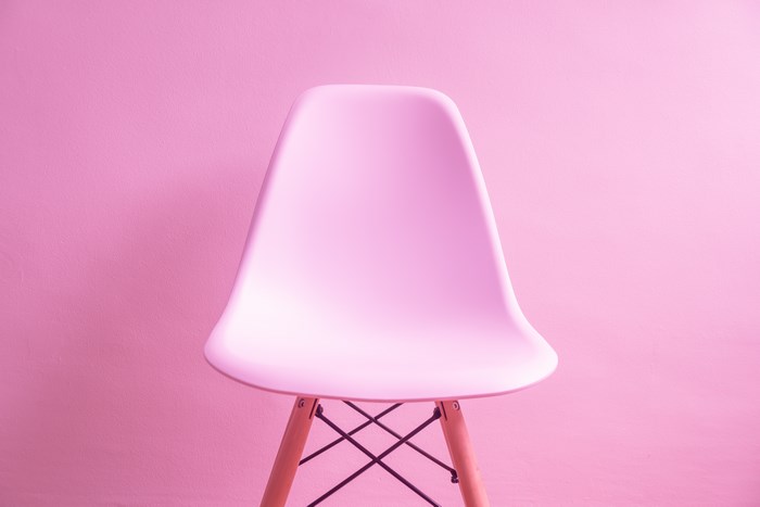 Pink Eames chair against a pink wall