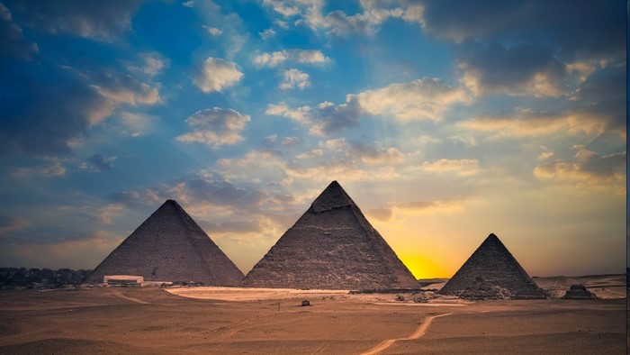 Pyramids of Giza at sunset with clouds