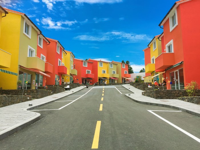 Colorful houses on a street with parking spaces