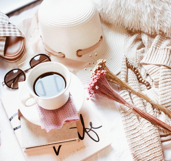Boho chic flat lay with coffee, hat, and sunglasses