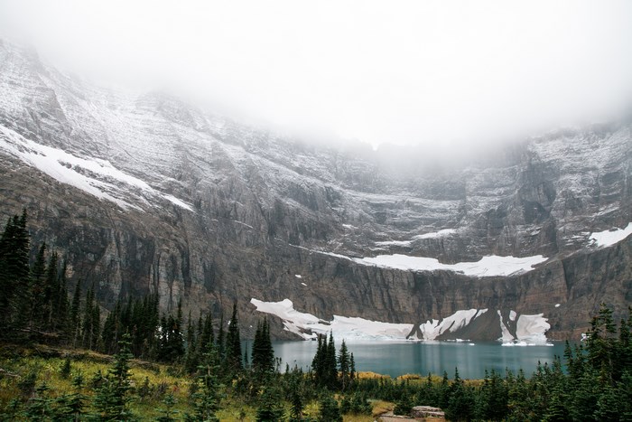 Glacier National Park lake with snow-capped mountains and fog