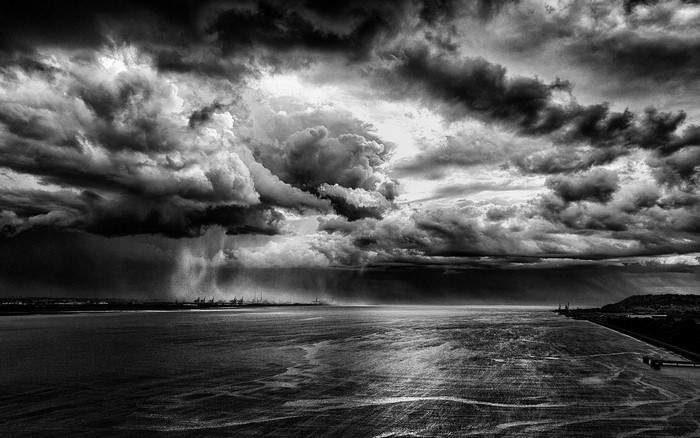 Stormy sky over a body of water with industrial structures