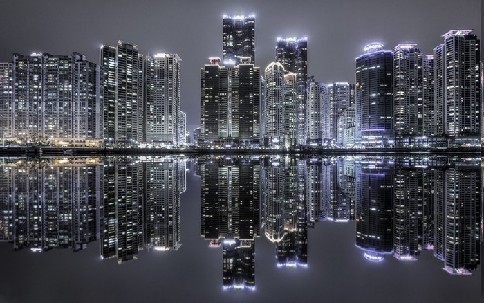 Modern skyscrapers reflected in water at night