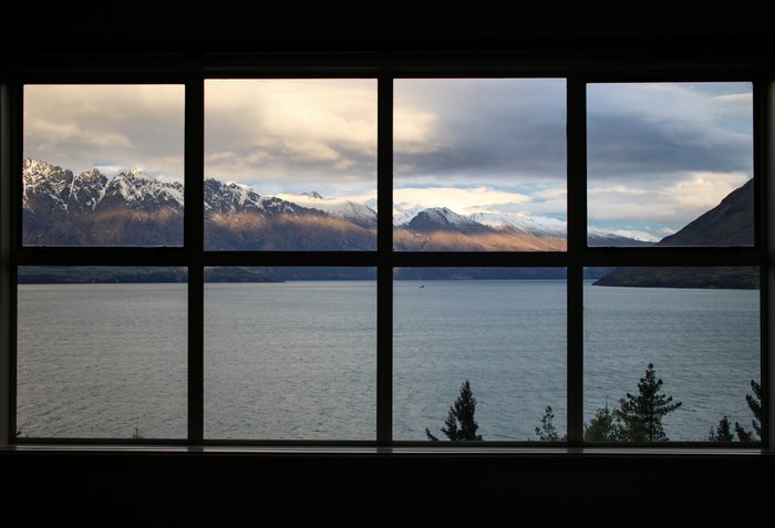 Snow-capped mountains and lake viewed through a window