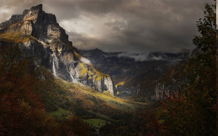 Dramatic Alpine Mountain Valley with Waterfalls and Clouds