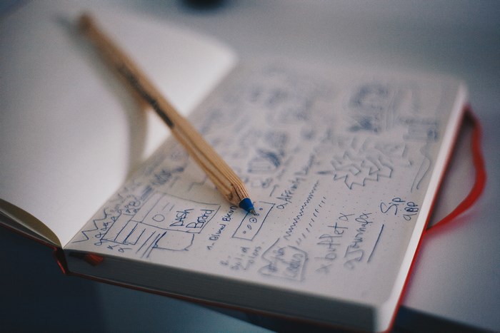 Notebook with sketches and a wooden pen