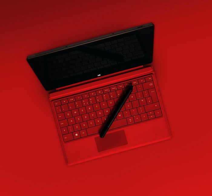 Red Microsoft Surface Pro tablet with pen and keyboard