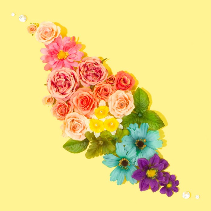 Rainbow flower arrangement with pearls on yellow background