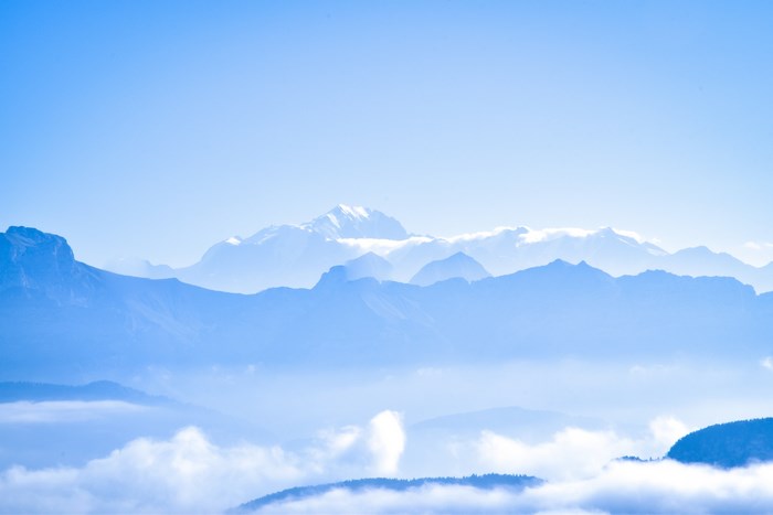 Misty Blue Mountain Summit with Snow and Clouds