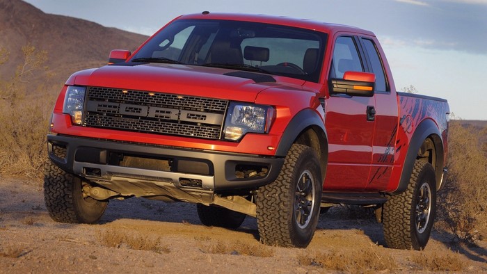 Red Ford Raptor truck in desert landscape