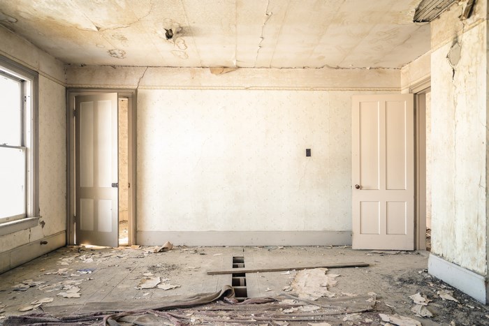 Abandoned room with damaged walls and floor