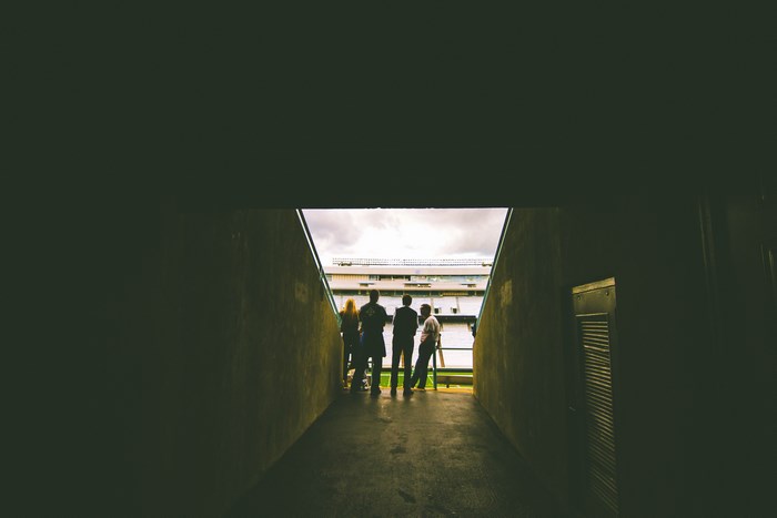 People in a stadium tunnel looking out