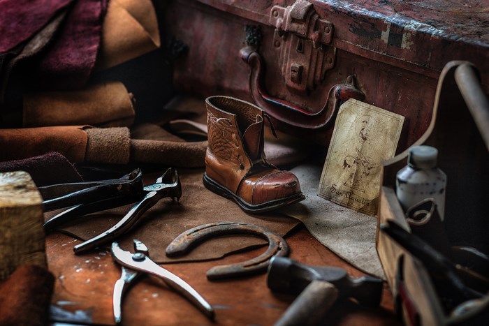 Cobbler's tools and materials with a boot and horseshoe