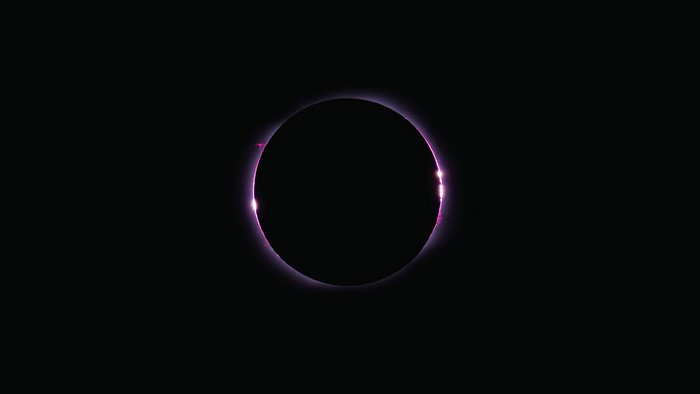 Solar eclipse with pink corona and prominences