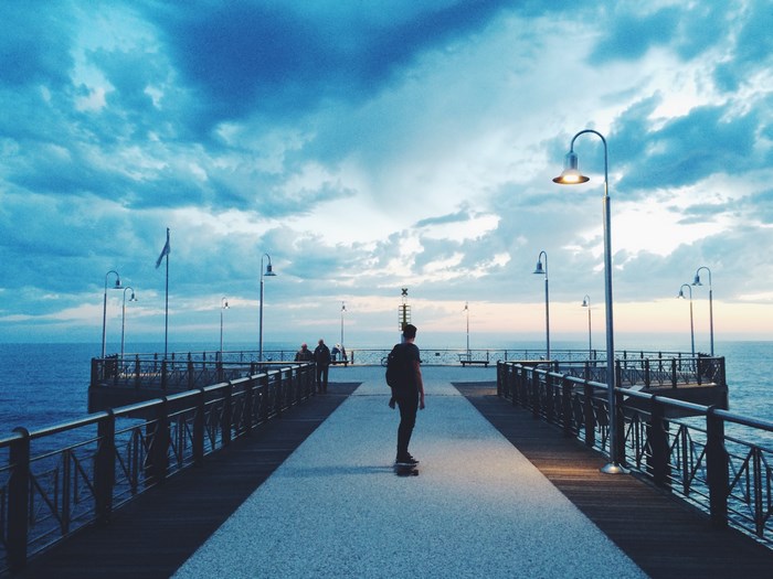 Man skateboarding on a pier at dusk