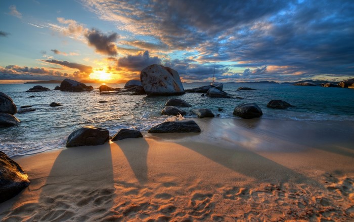 Sunset over a rocky beach with dramatic clouds