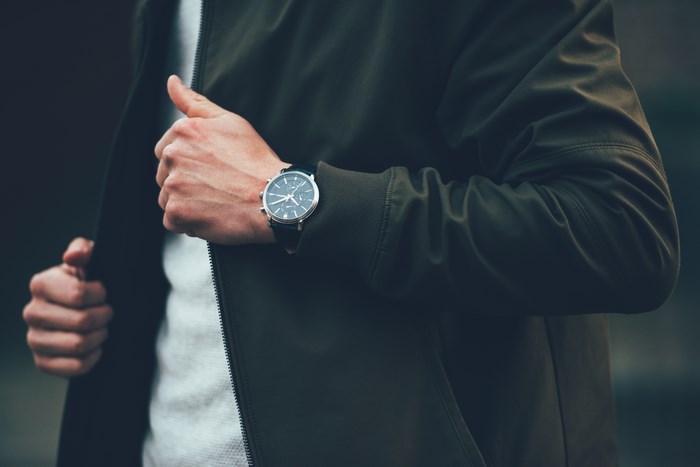 Man wearing a dark jacket and a watch