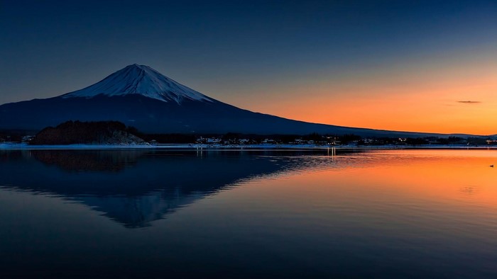 Mount Fuji reflected in a lake at sunset